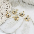 Macro view of sun-shaped gold pendants with blue rhinestones for DIY jewelry making - Blue Sun