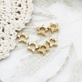 Close-up of six gold star-shaped hollow beads for DIY jewelry making on lace fabric - Hollow Star