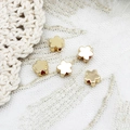 Macro shot of five gold flower spacers with side holes for DIY jewelry making - Flower
