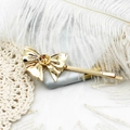 Elegante fermaglio per capelli a fiocco dorato placcato 18K su sfondo di piume bianche - Stile Fiocco