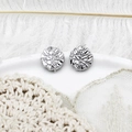 Detailed view of silver stud earrings with unique crushed metal texture on a white tray - Platinum Textured Round Style