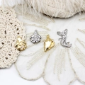 Vue macro de pendentifs bijoux marins avec méduses et coquillages sur dentelle - Étoile de mer Saint-Jacques Dorée (12.7*17.2mm)