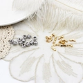 Detailed view of silver coil cylinders and golden star charms on white lace background - Star Style (G0526) / 3.5x9.3mm / 18K Gold