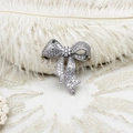 Detail of elegant bow brooch with shimmering zircons on white feather and lace texture - 30.7*34.5mm / White Gold Micro-pave Bowknot