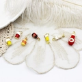 Detailed view of colorful enamel soda and beverage bottle charms for DIY jewelry - Yellow Beer