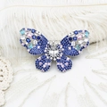 Détail d'une broche papillon en argent avec zircons multicolores et support de pierre centrale - Papillon de fleur