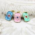 Detailed macro of gold-plated tarot pendants with sun patterns in three vibrant colors - Pink Sun Square