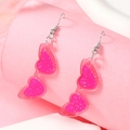 Detail van roze hartvormige zonnebril oorbellen met glitter in transparant acryl - Rose Roze Hart Zonnebril (WEH3940)