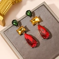 Macro shot of tiered geometric earrings featuring red, yellow and green faceted gemstones - KC Gold / Red