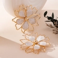 Detail of flower earrings with gold finish and white marble texture inlay on a desk - White Pearl Drop Earrings