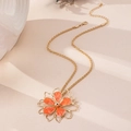 Close-up of golden necklace with orange flower pendant and rope chain detailing - Orange Necklace
