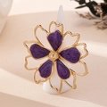 Macro detail of golden flower ring with deep purple enamel petals on a jewelry stand - Purple Ring