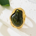 Detailed macro of vintage gold irregular metal ring with large dark green resin stone - Green