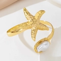 Macro detail of golden starfish and baroque pearl on a textured metal open arm cuff - Starfish Style (S-7-s019-Starfish Armlet)