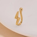 Dettaglio macro di un finto anello da naso a fulmine dorato con finitura lucida - Fulmine