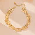 Close-up of gold geometric meander link bracelet with lobster clasp and extension chain - Anklet