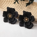 Détail macro de boucles d'oreilles fleurs noir mat avec étamines dorées et centre cristal - Noir