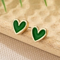 Detailed macro view of heart-shaped gold studs with dark green enamel finish - Green
