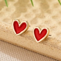 Detailed view of heart-shaped earrings with gold metal edges and vibrant red enamel filling - Red