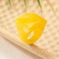 Macro detail of yellow marble resin geometric ring on warm textured stone surface - Yellow
