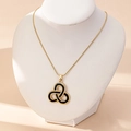 Dettaglio della collana a catena serpente dorata con ciondolo a nodo celtico nero e oro su busto - Collana con Fiore Singolo / Nero