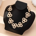 Dettaglio collana vintage dorata con ciondoli in smalto bianco su un manichino nero - Collana con Fiori Multipli / Bianco