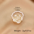 Détail d'une bague rose blanche avec bords dorés et chaîne perles montrant 2,6cm - Blanc