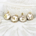 Detailed close-up of 18K gold-plated zodiac pendants with white shell and inlaid crystals - Capricorn