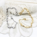 Detailed shot of wave-shaped chain bracelets in gold and silver finish with swan charms - Irregular Wave Bracelet Style / Gold