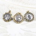 Macro view of vintage Greek coin pendants with embossed goddess portraits and gemstones - Left Green Rhinestone Portrait