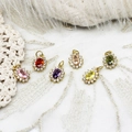 Macro shot of oval colored gemstones with zircon halos on elegant lace and feather background - Pink Zircon Oval Style