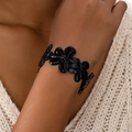 Elegant black flower open cuff bracelet with textured petals worn on a wrist - Black