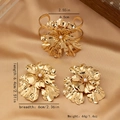 Detail of gold flower jewelry set featuring pearl centers and textured petals - Gold