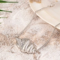 Chic conch shell anklet in silver finish lying on white beach sand for summer style - Conch Style (JL002) / Silver