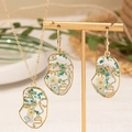 Elegantes Schmuckset aus Gold mit transparentem Harz und echten Trockenblumen - Abstraktes Gesicht Blaue Blume