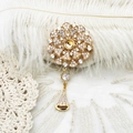 Detailed macro of a gold flower brooch with white zircon and pearl base on lace - 18K Gold Fireworks