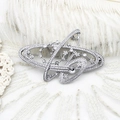 Elegante spilla a forma di pianeta argento con zirconi su sfondo di piume bianche - Forma di pianeta Saturno / Argento