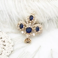 Spilla corona dorata di lusso con gemme blu scuro su pizzo bianco elegante - Corona Oro 18K 30.5*37.3mm