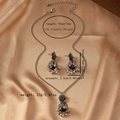 Close-up of vintage flower bell jewelry set with necklace and earrings on silk - Antique Silver
