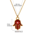 Detail view of gold Hamsa Hand pendant with red enamel and dimensions 23mm by 18mm - Red