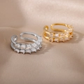 Detail of gold and silver bird nest rings featuring baguette-cut zircon inlay on satin - Double Layer Geometric Gold