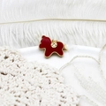 Detailed macro view of an Ancora red rocking horse pendant with gold bead trim and coin motif - Red Rocking Horse Pendant