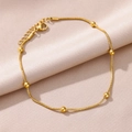 Detailed close-up of a gold-plated snake chain anklet with polished beads on satin - Gold Seven Beads Style (HJ367G)