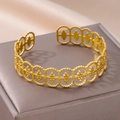 Detailopname van een gouden open armband met geometrische gehamerde patronen - Geometrische Holle Boheemse Stijl (B1356G)