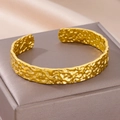 Macro-detail van de gouden gehamerde textuur op verstelbare minimalistische C-armband - Minimalistische C-vormige Gehamerd Stijl (B1372G)