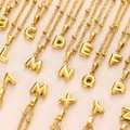 Detailed macro view of 18K gold plated bubble letter pendants on bead chains - Letter A / Gold