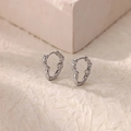 Vue macro détaillée des boucles d'oreilles cœur en argent avec texture martelée lave - Argent Texture de Lave Irrégulière