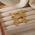 Detalle macro de un broche de mariposa en metal líquido dorado con piedras de circón - Broche de Mariposa Dorado (G12305581)