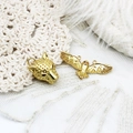 Macro detail of 18K gold-plated leopard and owl pendants on white lace fabric - Leopard Design