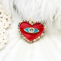Macro detail of gold evil eye heart pendant with red enamel and multicolor gemstones - Heart Evil Eye